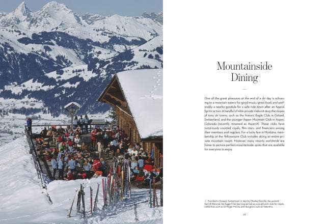 People gathered outside a wooden cabin with snow-covered mountains in the background