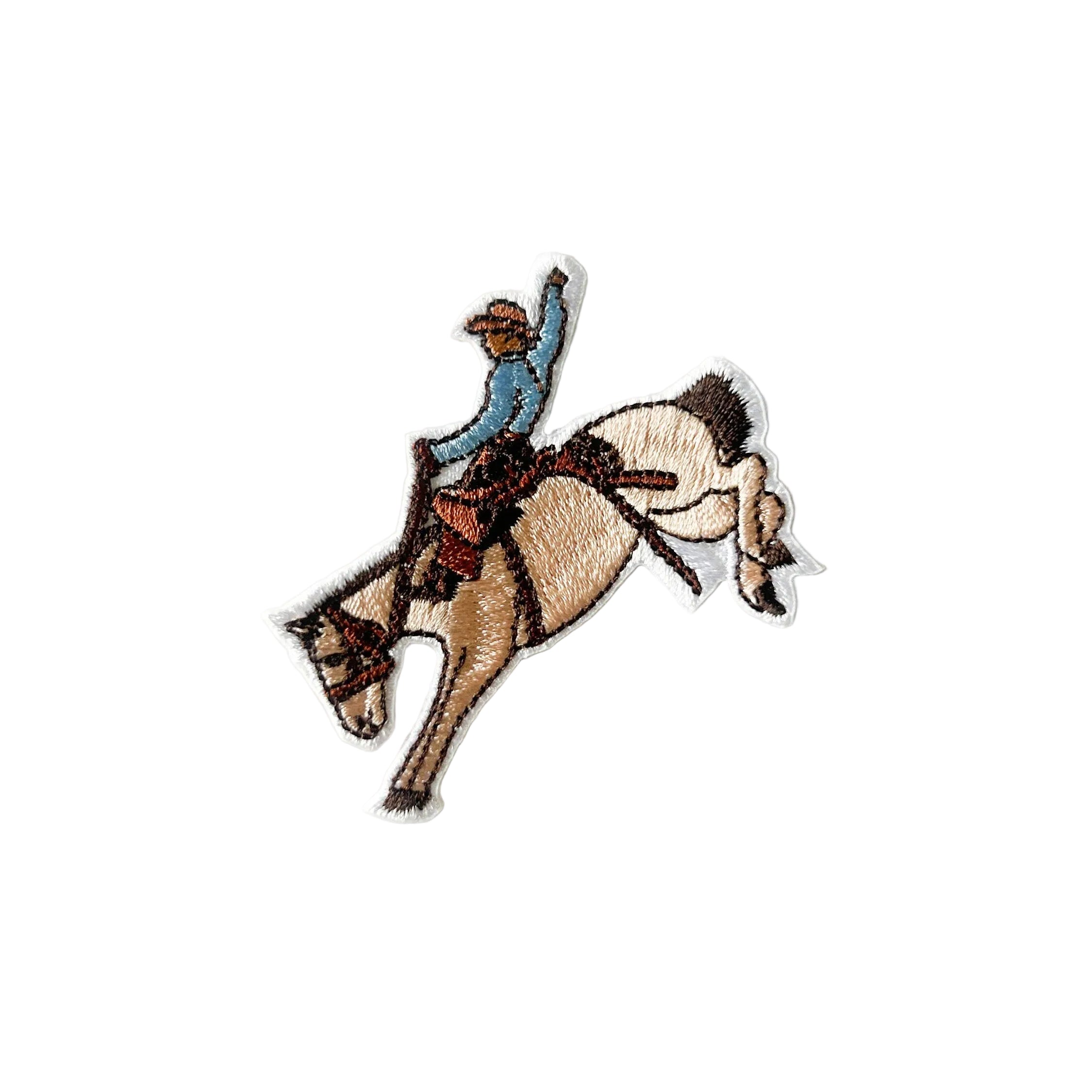 Embroidered iron on patch of a cowboy riding a bucking horse.