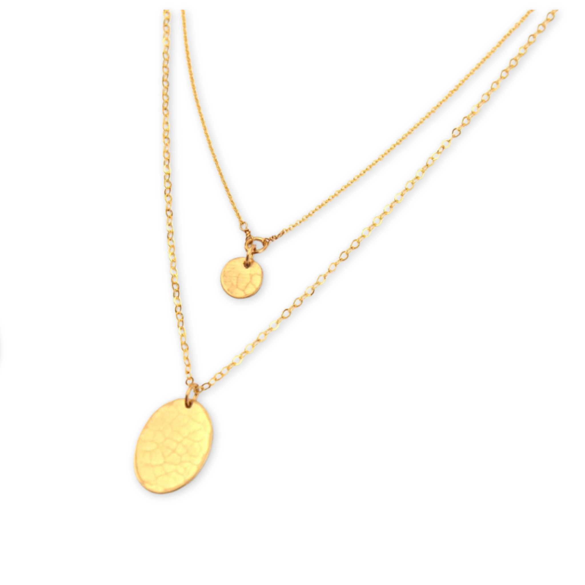 two layering necklaces featuring a textured round disc and a textured oval both hanging on simple chains