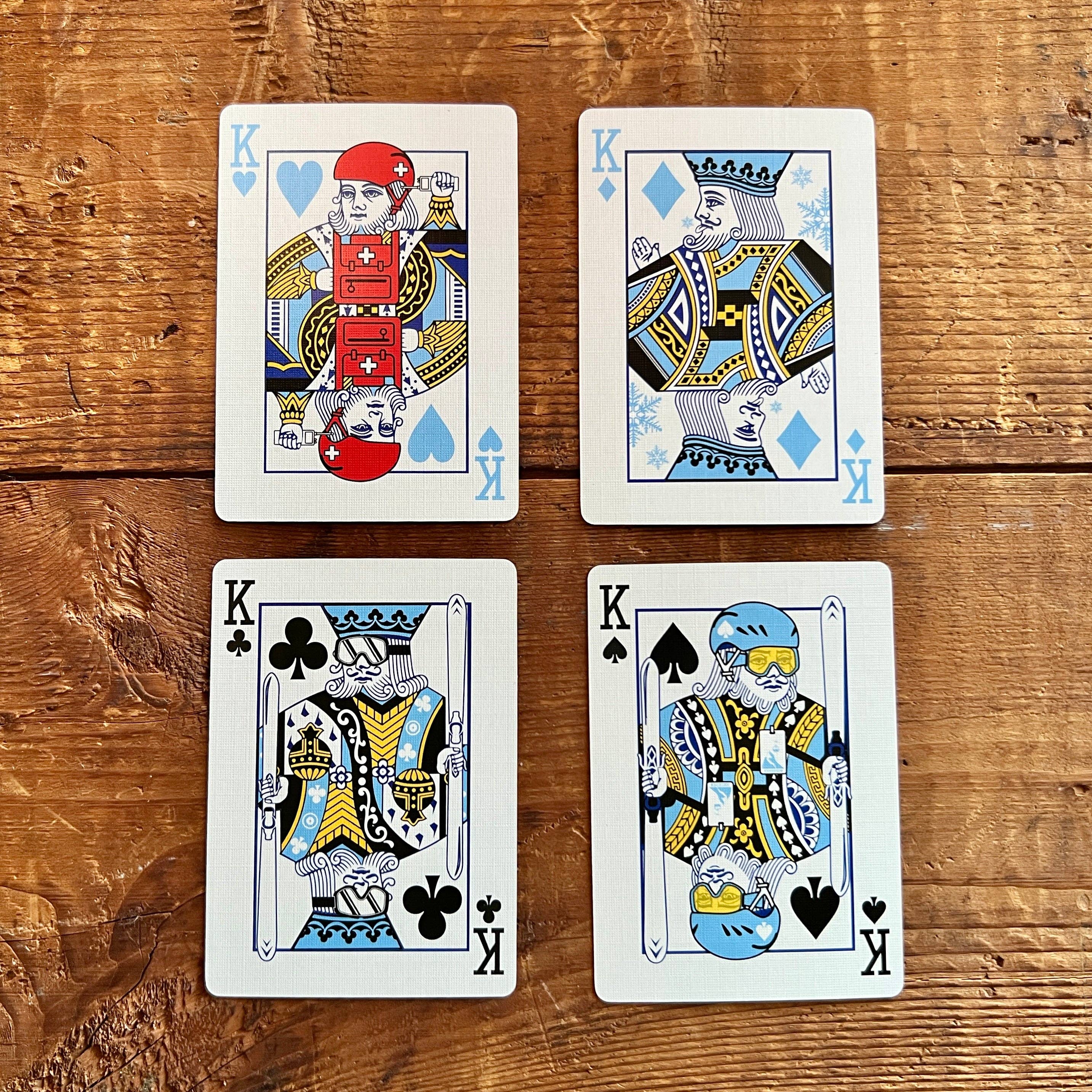 Four kings from different suits on a wooden surface