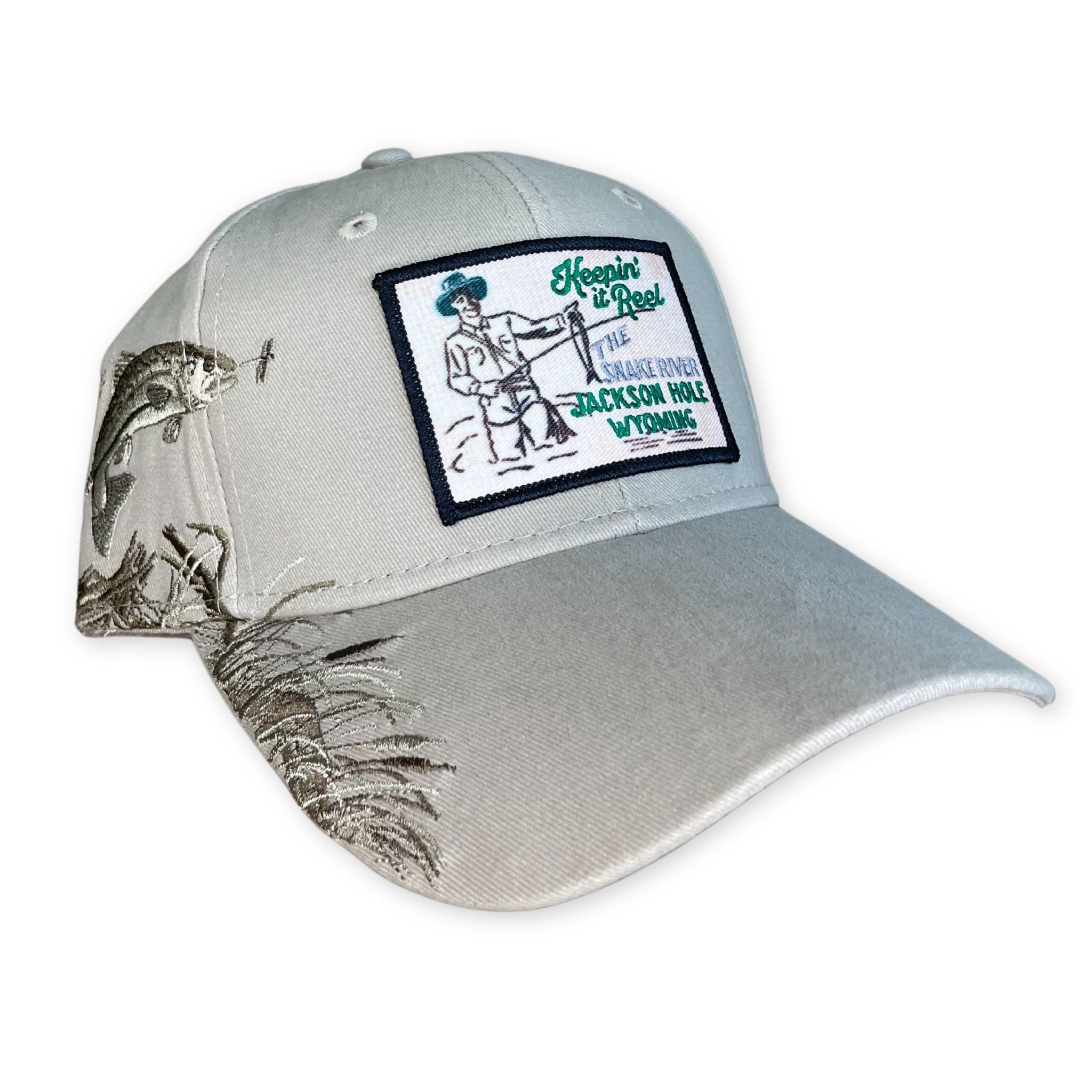 Tan hat with embroidered fish design on the side. patch on the front.