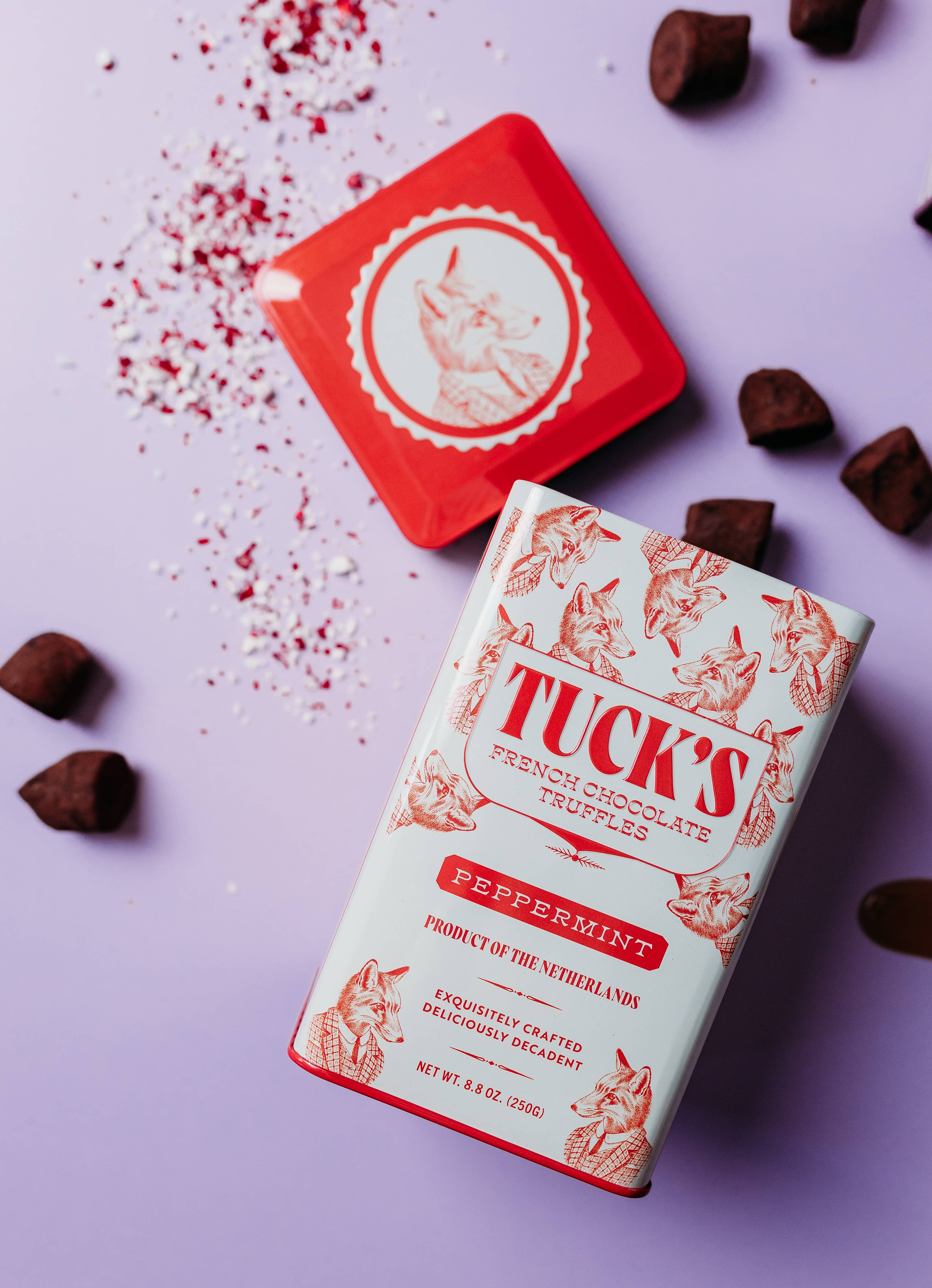 Tuck's French Chocolate Truffles packaging on a purple background with truffles around