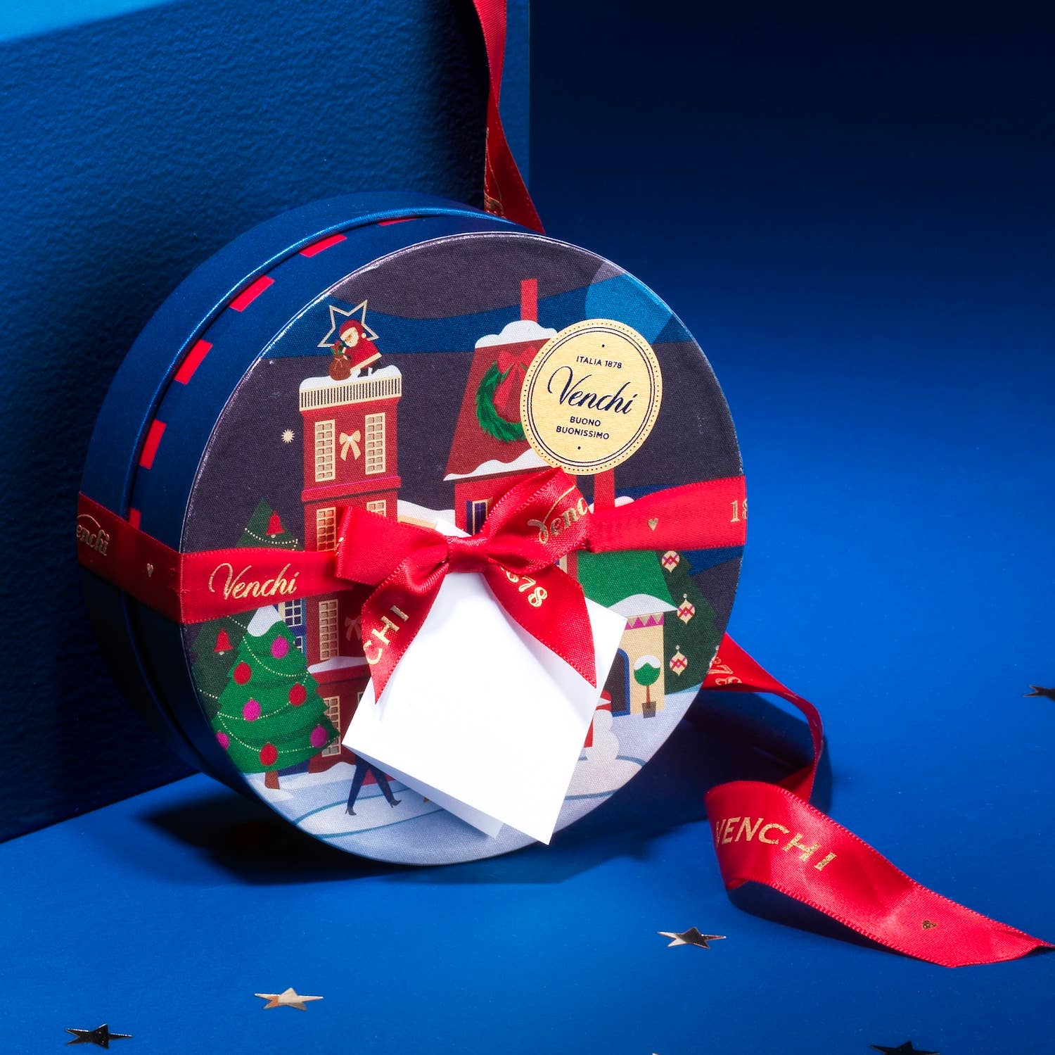 Decorative chocolate box with festive design and red ribbon on a blue background