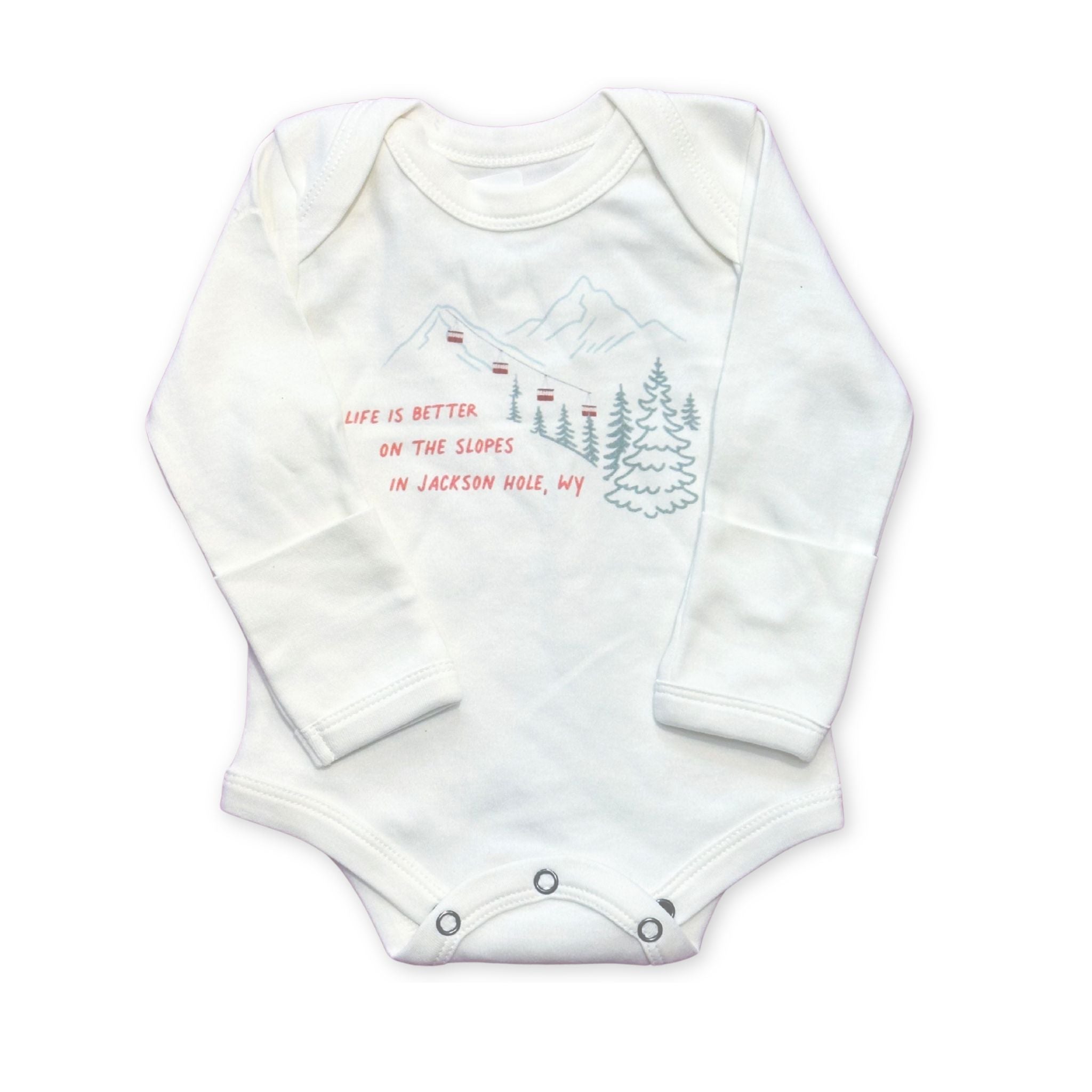 White long sleeve baby onesie, with mountains. tram, and trees. Text reads "Life is better on the slopes in Jackson Hole, WY".