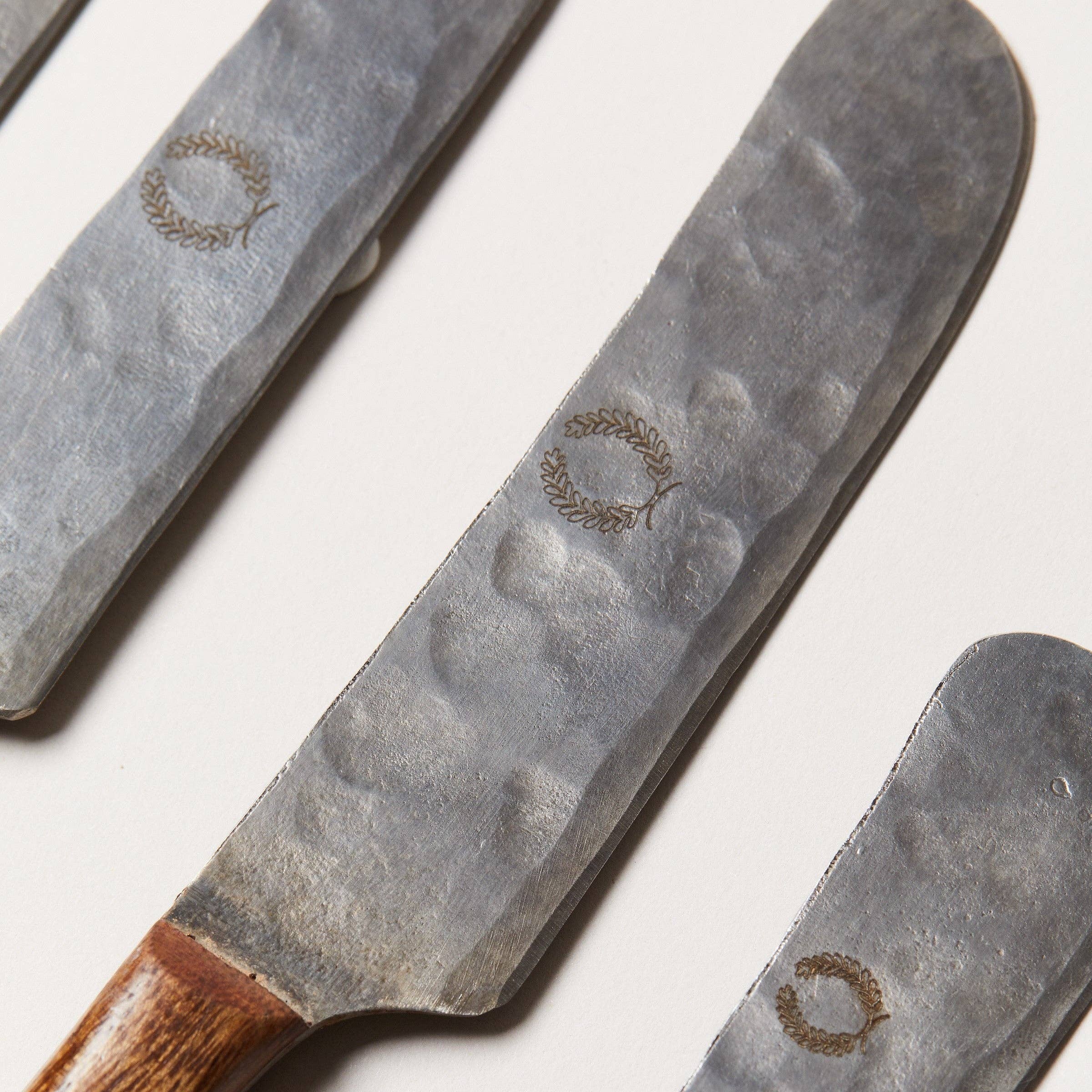 Three metal knives with wooden handles on a white background