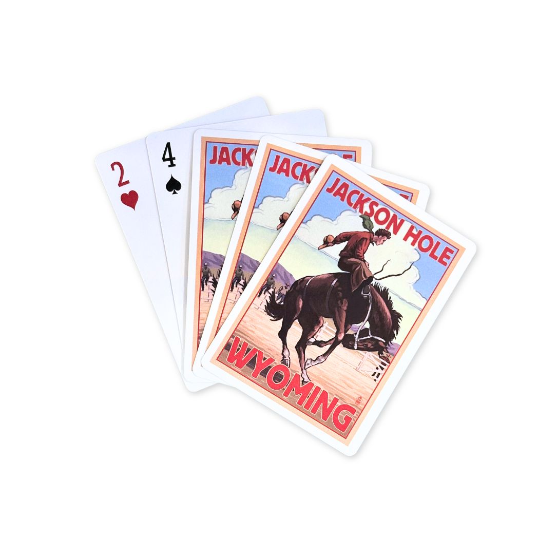 Playing cards with a cowboy riding a bucking bronco. With the text in red stating "Jackson Hole Wyoming" 