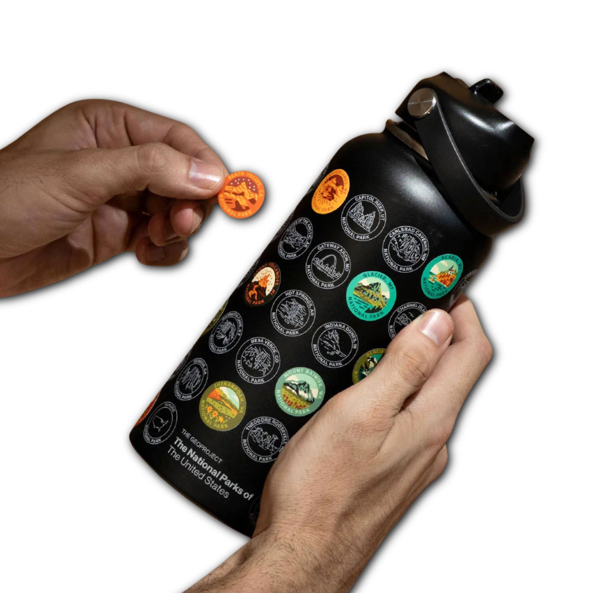 Black water bottle with national park stickers being held by a hand