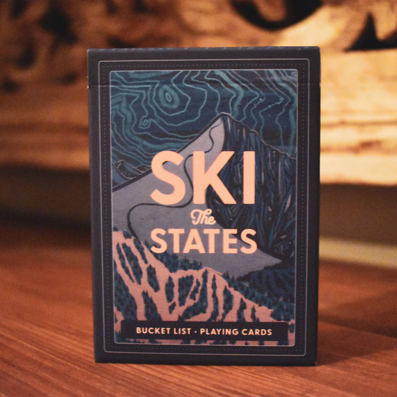 Playing cards with 'Ski the States' design on a wooden surface