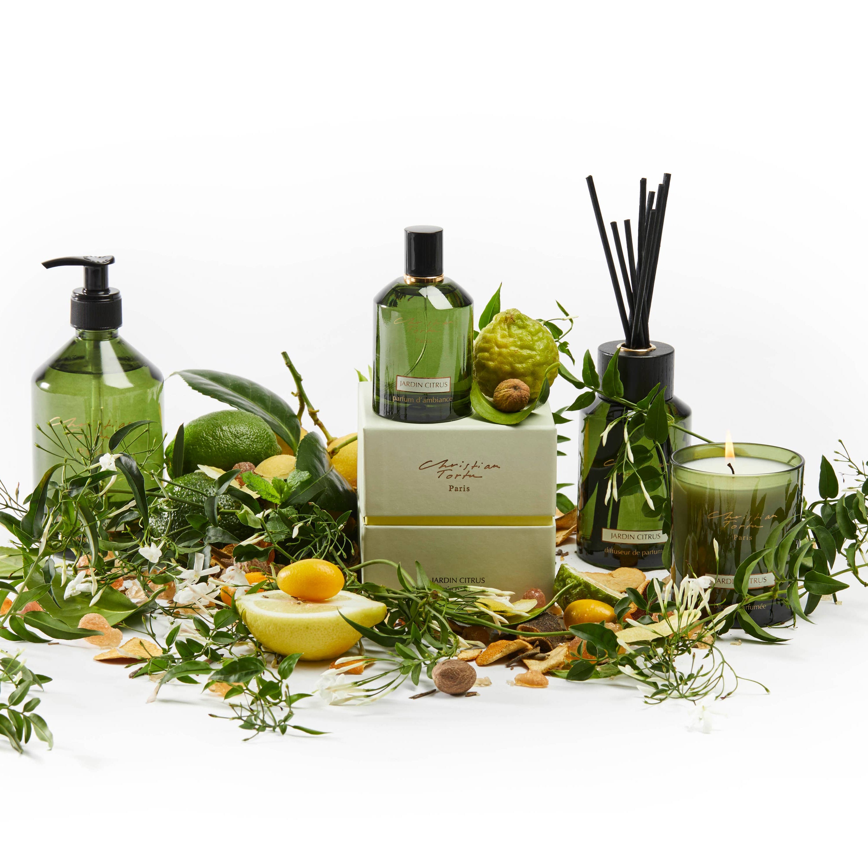 Collection of green-themed products including bottles, candles, and decorative items on a white background.