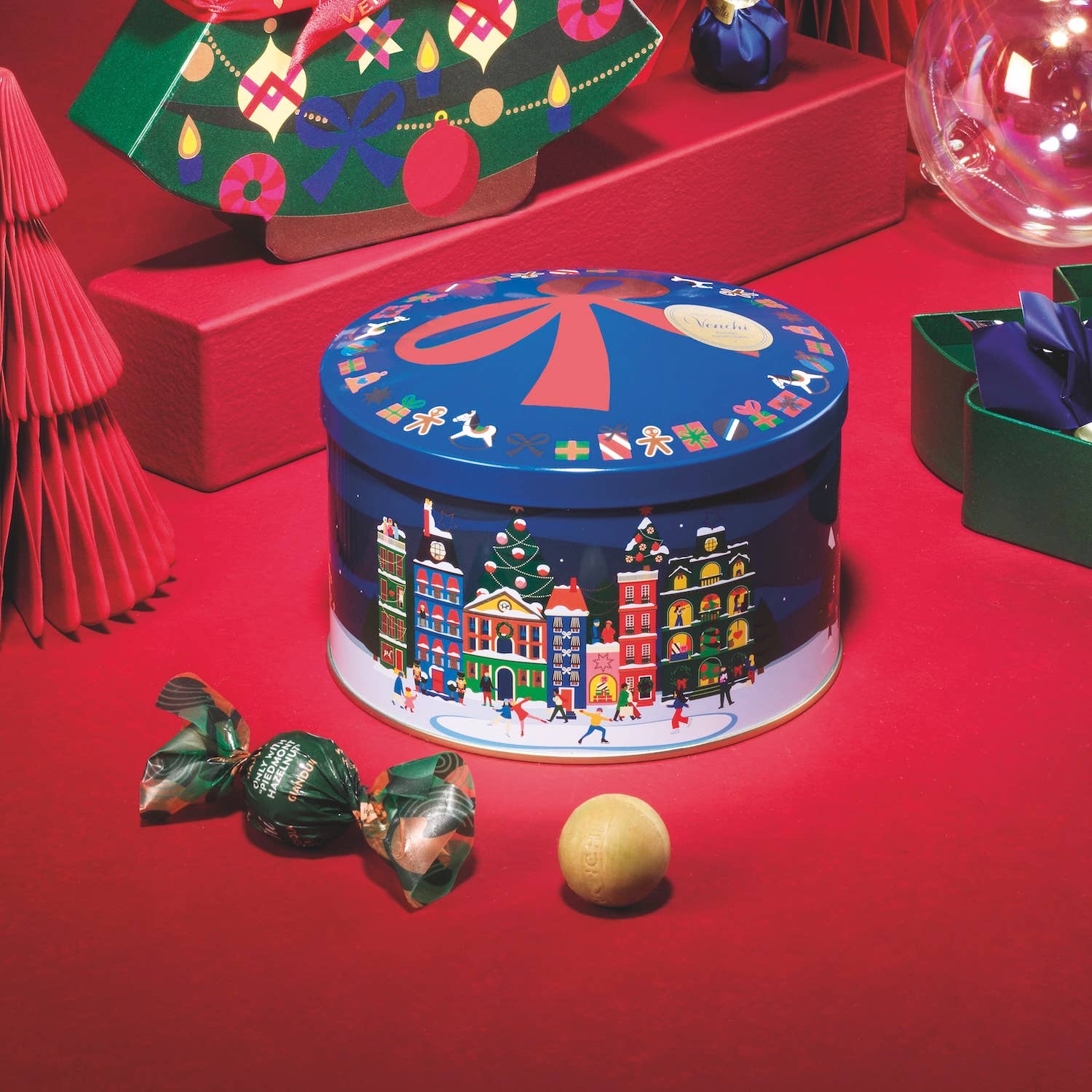 Decorative Christmas tin with festive design on a red surface